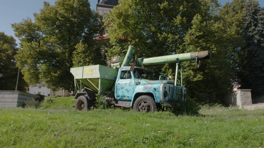 An old rusted truck with a missile in the back stands abandoned in a lush green park in Tallinn on Estonia