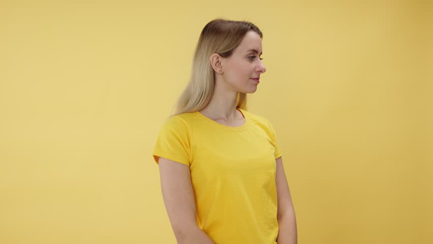 Female in bright clothes receiving flowers and enjoying attention from boyfriend. Smiling woman holding tulips bouquet and feeling happy with unexpected gift while standing over yellow background. Royalty-Free Stock Footage #3429941379