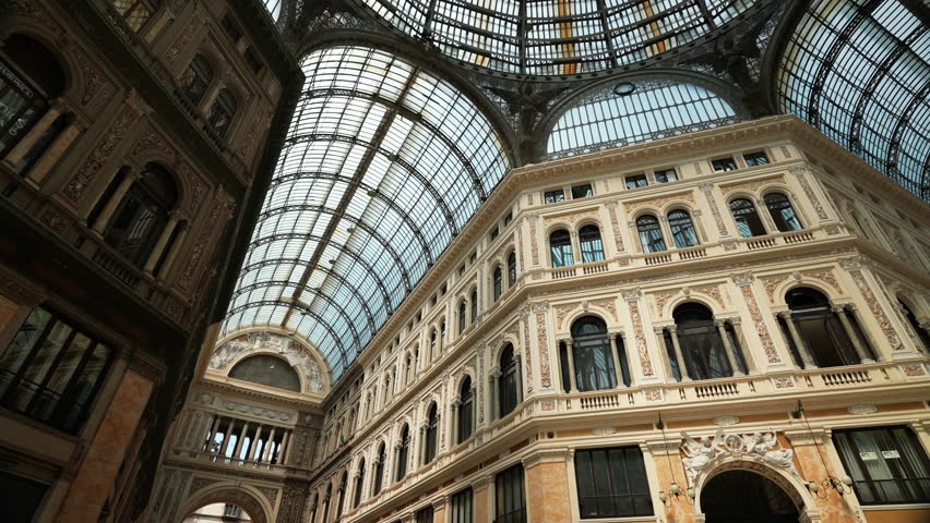 View of the glass ceiling of the historic Royal shopping Arcade Galleria Umberto, Historic public shopping gallery with old Architecture and Glass Arch Ceiling, 