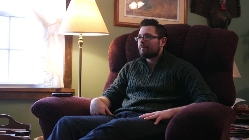 Handsome Caucasian Millennial Male laughs at a comedy skit or movie on tv