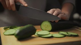Cucumber. Preparing a salad. Healthy Lifestyle. Dietary nutrition. Slicing. Green fresh cucumber. Stainless steel knife. Kitchen accessories. Food slicer. Wooden plank. Cooking. Chef. Salad cucumber - Powered by Shutterstock - Get 15% off with code: PIKWIZARD15