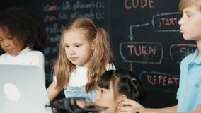 Smart caucasian girl using laptop programing engineering code and writing program surrounded by multicultural friends in STEM technology classroom at blackboard written with coding prompt. Erudition. - Powered by Shutterstock - Get 15% off with code: PIKWIZARD15