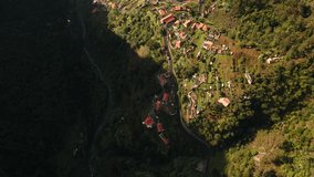 Aerial top down view of Madeira island, small village in a valley during sunset golden hour