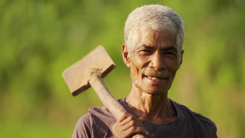 portrait of senior asian farmer in rural asia with traditional tool, subsistence farming