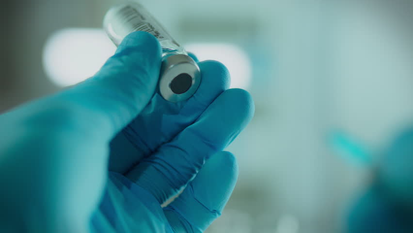 Disease. A surgeon in a white coat prepares medicine for anesthesia in his office. Camera movement qualified doctor draws medicine into a syringe innovative research in the field of surgery, needle