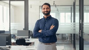 Happy confident Indian businessman professional leader wearing blue shirt standing arms crossed in office. Smiling business man company executive manager worker, eastern entrepreneur at work,portrait. - Powered by Shutterstock - Get 15% off with code: PIKWIZARD15