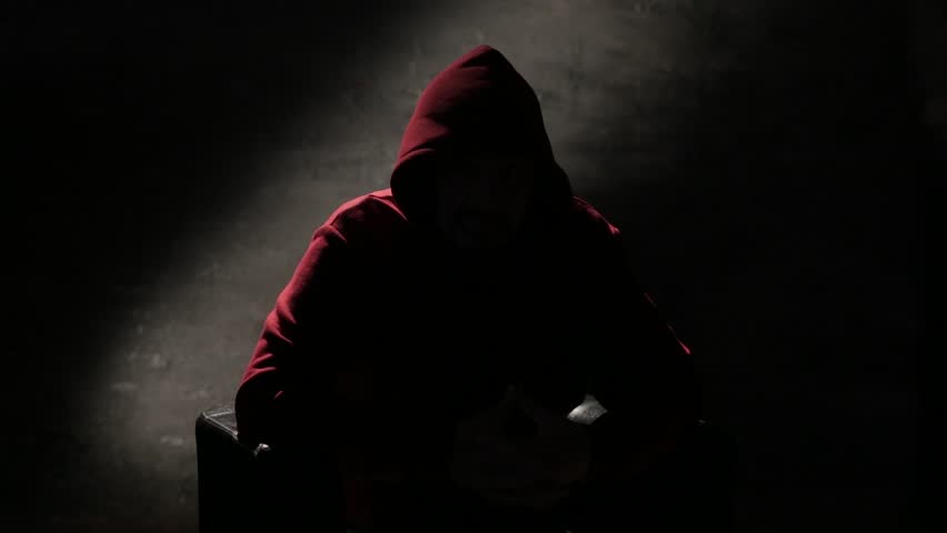 Anonymous man in a hood interview video footage, mysterious man sitting on a chair and talking. Anonymous hacker interview with no visible face footage, computer hacker conceptual background Royalty-Free Stock Footage #3430233281