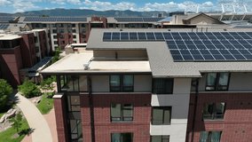 Modern college dorm with solar panels and energy efficiency rating animation, green courtyard, mountain backdrop. Special effects showing EPC A, B, and C rated housing buildings. Aerial. - Powered by Shutterstock - Get 15% off with code: PIKWIZARD15