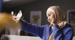 Muslim woman in hijab woman taking selfie. Young teenage Muslim woman, generation Z, happy cheery female blogger, muslim woman in hijab taking selfie for avatar in social networks, for blog online.
