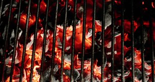 Close-up. Grill radiates inviting warmth, fueled by burning coals that promise mouth watering barbecue. Red hot coals crackle under grill grate, setting stage for fun outdoor feast. AD. Copy space.
