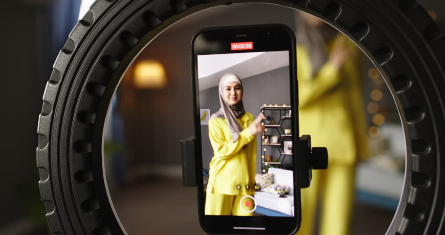 Female blogger dancing for phone camera. Screen display shooting video on phone camera. Shooting reels stories getting likes audience of loyal admiring followers. Dance blogger with bunch of followers