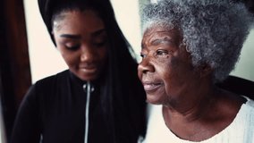 African American granddaughter hugging elderly 80s grandmother showing support and help for inter-generational family member. Family unity and love during old age - Powered by Shutterstock - Get 15% off with code: PIKWIZARD15