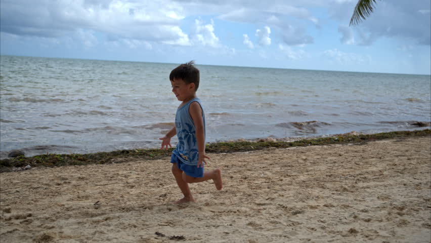 Slow motion of a young latin boy wearing shorts running on the beach chasing his mother and smiling. Vacations freedom concept Royalty-Free Stock Footage #3430303833
