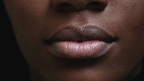 One young black woman's wide grin with white intense vibrant teeth. Adult girl of African descent smiling in macro close-up detail of mouth and lips - Powered by Shutterstock - Get 15% off with code: PIKWIZARD15