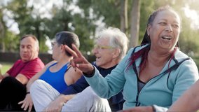 Multiracial group of senior people having fun after exercise yoga workout at park. African woman laughing with friends - Powered by Shutterstock - Get 15% off with code: PIKWIZARD15
