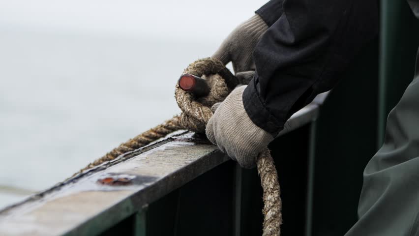 Hands in close-up tie rope in slow motion showcasing the art of knot security To tie rope on ship means to ensure reliability sailor's skill. Learn to tie rope master maritime safety Royalty-Free Stock Footage #3430383795