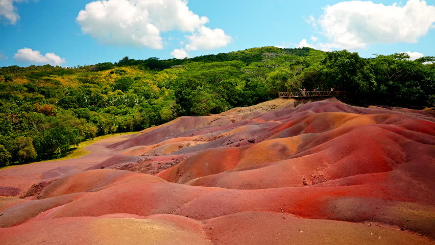 Panoramic shot of the Seven Colored Earths Chamarel national park in the Mauritius Island. Traveling fluffy clouds. Vibrant colors, sand dunes. Touristic attraction. Terres des Sept Couleurs. Royalty-Free Stock Footage #3430390323