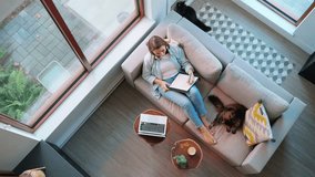 Overhead view of woman writing notes, lying on couch at home - Powered by Shutterstock - Get 15% off with code: PIKWIZARD15