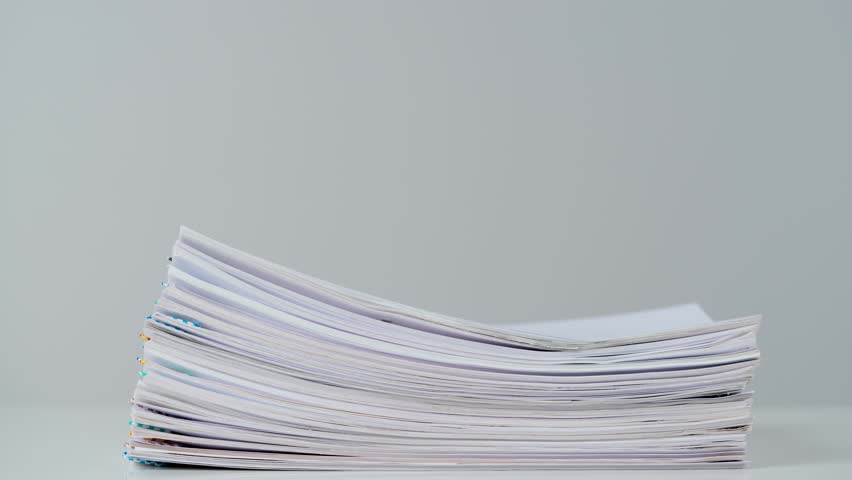 Time lapse studio shot of paper sheets. Stop motion animation of business or educational paper documents with paper clips at the desk