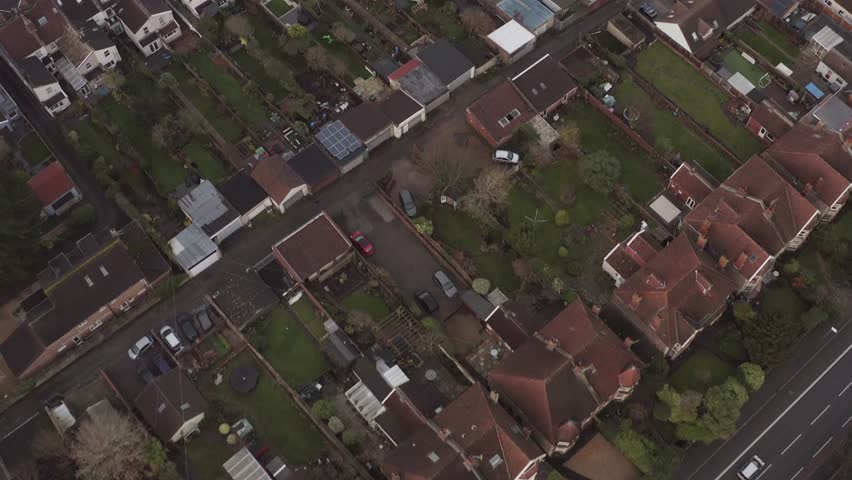 Overhead aerial moving diagonally over English terraced houses with large gardens, UK Royalty-Free Stock Footage #3430454543