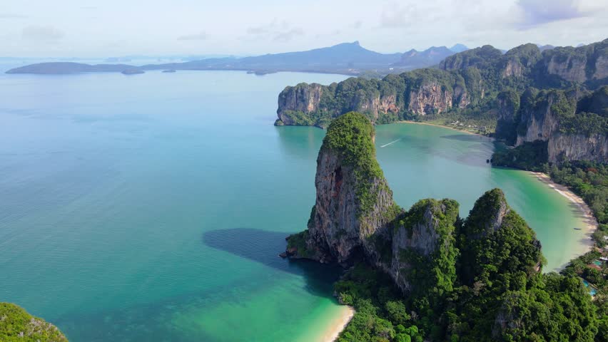 Railay Beach Krabi Thailand a tropical beach with a turqouse colored ocean, Railay Krabi view from a drone of idyllic Railay Beach in Thailand in the evening at sunset with a cloudy sky Royalty-Free Stock Footage #3430476915