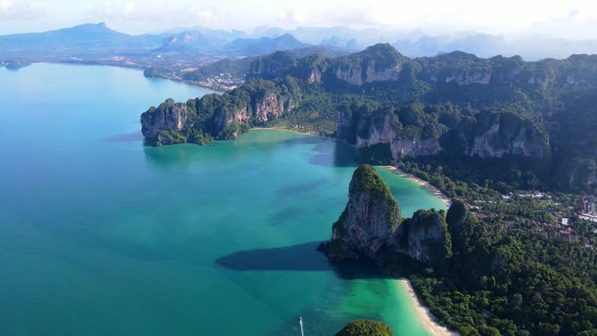 Railay Beach Krabi Thailand a tropical beach with a turqouse colored ocean, Railay Krabi view from a drone of idyllic Railay Beach in Thailand in the evening at sunset with a cloudy sky Royalty-Free Stock Footage #3430476981
