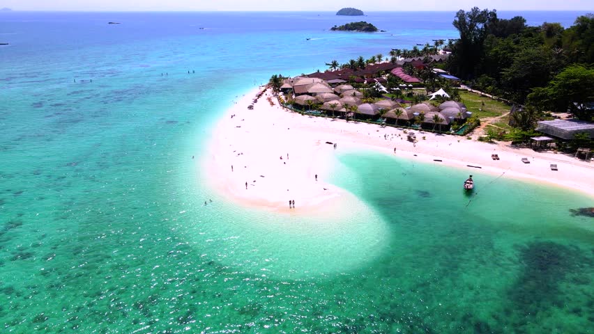 a couple of men and women walking at a white sandbank beach in the ocean of Koh Lipe Island Southern Thailand, with turqouse colored ocean and white sandy beach sandbar at Ko Lipe. Royalty-Free Stock Footage #3430488443