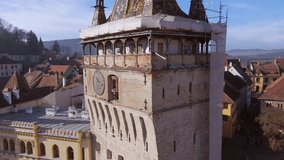 Aerial video of medieval city of Sighisoara from Romania, taken from a drone with the Clock Tower in the front. Close up footage of the clock in the Clock Tower from Sighisoara city, Romania.
