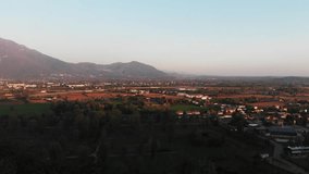 Cinematic video of italian countryside with fields and nature in spring with colorful trees. Drone video with fields and nature and alps mountain in background