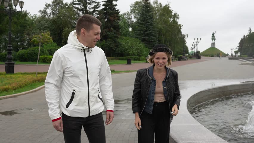Young people walk past the fountain and chat.