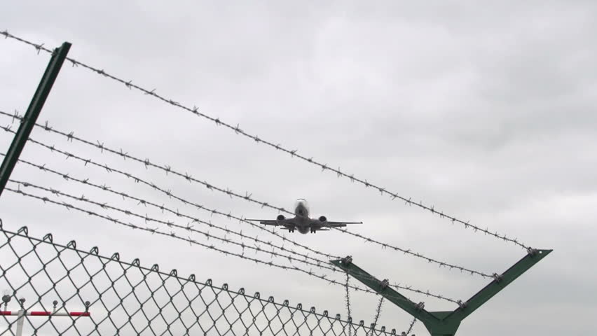 Airplane landing flies over barbed wire 