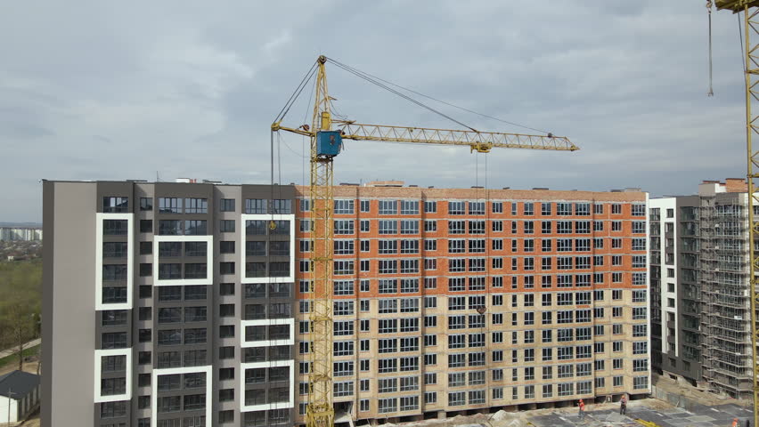 Tower cranes at high residential apartment buildings construction site. Real estate development
