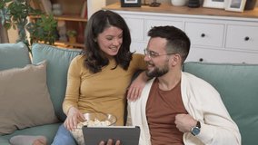 Couple man and woman caucasian husband and wife or boyfriend and girlfriend sit on the sofa bed at home watch movie series with bowl of popcorn happy smile bonding love family concept copy space
