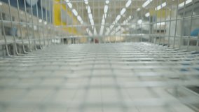 Customer shopping at supermarket with trolley inside pov view. Time lapse of shopping cart in the super market aisle. Grocery shopping and retail concept. Stop motion timelapse video