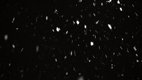 Snow falls at night on a black background. Falling Snowflakes