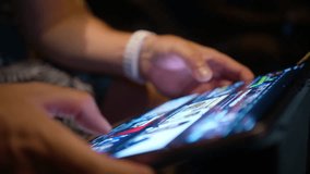 Young man scrolling content online, wireless internet. Closeup male hands searching on tablet screen, browsing videos or image content using WiFi at night. Close view modern tech device bright screen - Powered by Shutterstock - Get 15% off with code: PIKWIZARD15