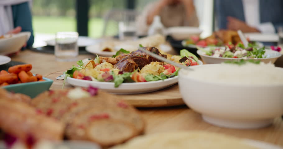Table, healthy food or hands of family in home with lunch, drinks or celebration in social gathering event. Group of people, eating or plate closeup with dinner, meal or brunch with salad or bowl Royalty-Free Stock Footage #3431107153
