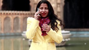 4K Video : Young women talking on mobile phone at Galtaji Temple, Jaipur, Rajasthan, India.       