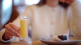 Woman drinking vitamin ginger immunity shot in a restaurant - Powered by Shutterstock - Get 15% off with code: PIKWIZARD15
