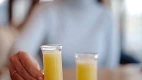 Woman drinking vitamin ginger immunity shot in a restaurant - Powered by Shutterstock - Get 15% off with code: PIKWIZARD15