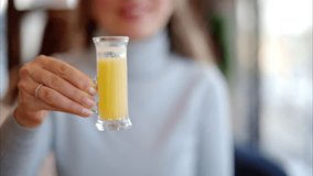 Woman drinking vitamin ginger immunity shot in a restaurant - Powered by Shutterstock - Get 15% off with code: PIKWIZARD15