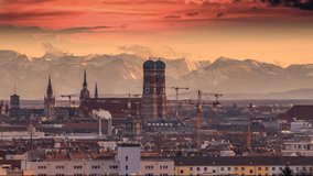 Beautiful sunset over Munich city skyline aerial view time lapse footage of munich germany in front munich frauenkriche church and alps mountains.
