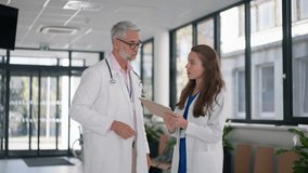 Doctors discussing something at hospital corridor. - Powered by Shutterstock - Get 15% off with code: PIKWIZARD15