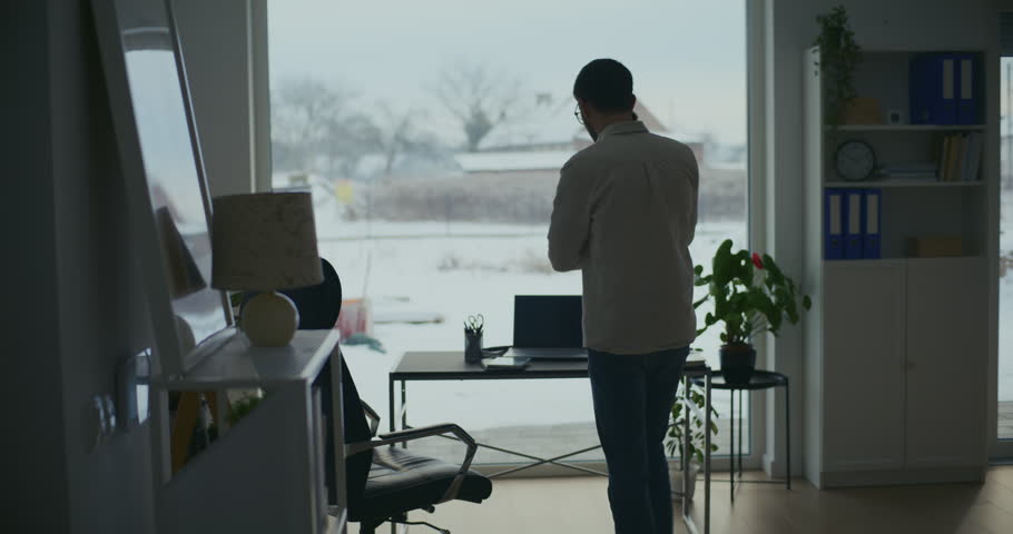 Young businessman sitting on office chair with laptop at desk
