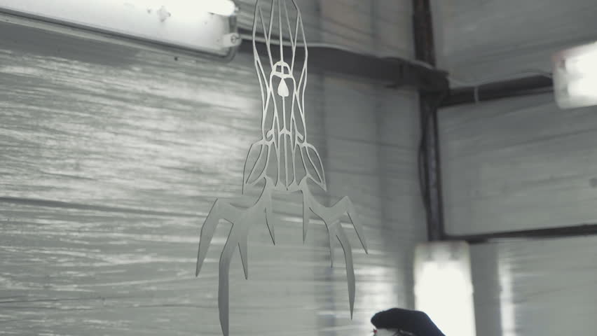 Artist colors decorative metal stylized deer head in black color at his workshop, slow motion.