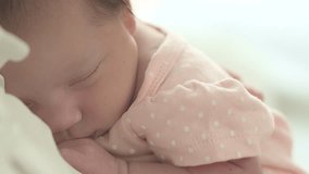 Close up adorable baby face Young mom cuddles cute newborn baby gently while little infant sleeping in Mom chest Asian mother looking at baby with love and take care daughter lull her baby to sleep  - Powered by Shutterstock - Get 15% off with code: PIKWIZARD15