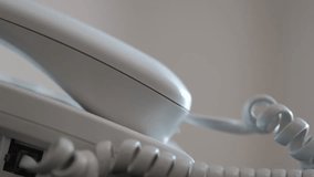 Close-up of a male hand picking up the receiver of a white landline telephone. - Powered by Shutterstock - Get 15% off with code: PIKWIZARD15
