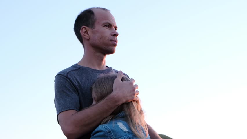 Dad caresses his daughter against the backdrop of the sky. Royalty-Free Stock Footage #3431472567