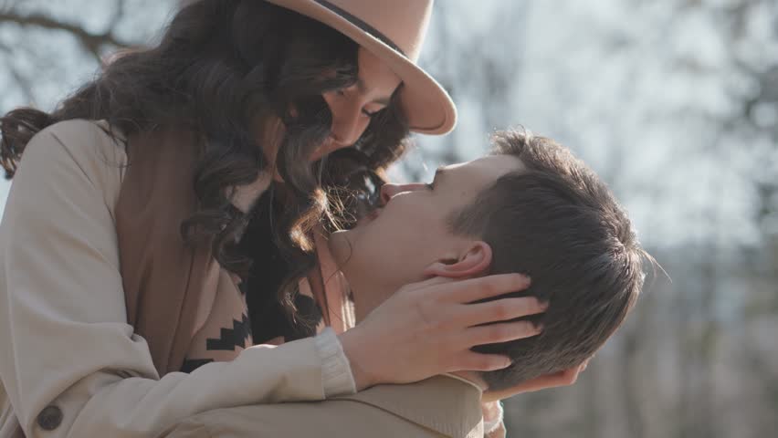 Cheerful outdoor couple, full of energy and spring look. Their smiles, like the sun, luxuriously illuminate the day. They look at each other, delving into the natural world that surrounds them. Their