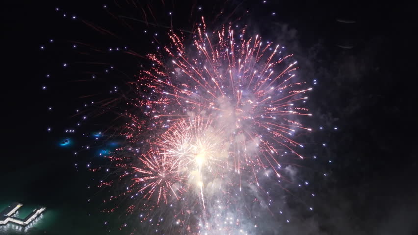 Drone flying above colorful sparkling fireworks exploding at night. Fireworks exploding in sky at Waikiki resorts. Tourists attraction on Oahu island Hawaii. People celebrating life on summer vacation